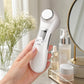 Close-up of 6-in-1 Beauty Device in hand highlighting its ergonomic design and sleek ABS material, with a blurred skincare setup background.