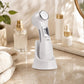 Full-body scene with the 6-in-1 beauty device resting upright on a minimalist skincare table surrounded by skincare essentials, in warm natural lighting.