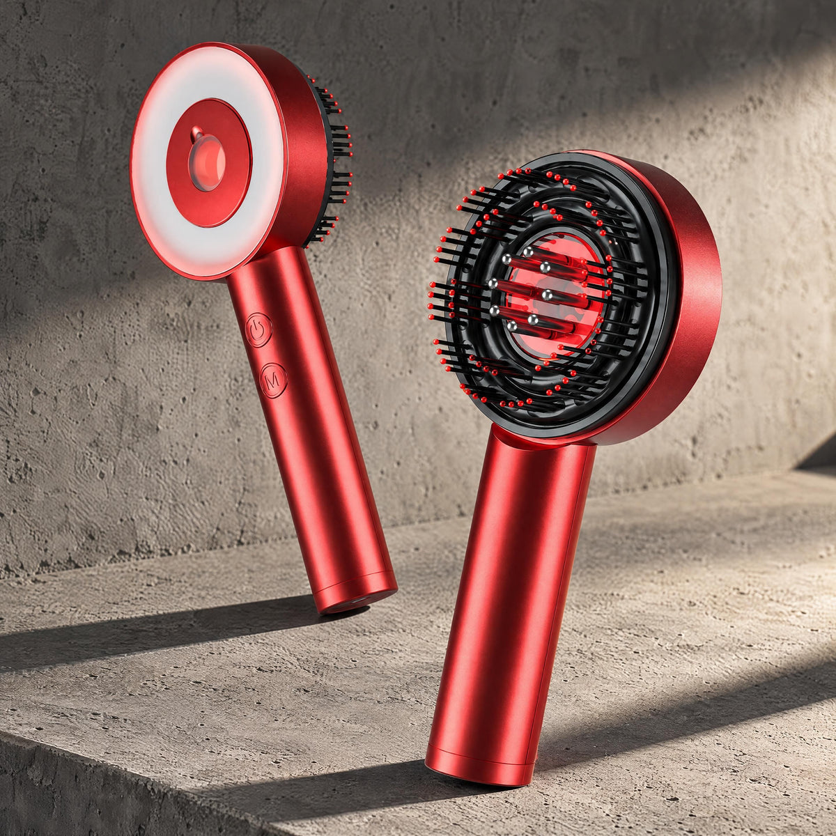 Grey 3-in-1 scalp massager resting on a brushed concrete surface, highlighting its metallic finish.