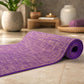 Elegant close-up of purple jute yoga mat, partially rolled, highlighting texture and craftsmanship in a luxury wellness setting.