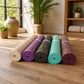 Display of Natural Jute Yoga Mats in various colors, arranged in a luxury wellness studio emphasizing natural textures and sophisticated style.