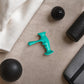 Top-down view of the trigger point massager on a fabric surface, surrounded by massage accessories in a home or therapy setting.