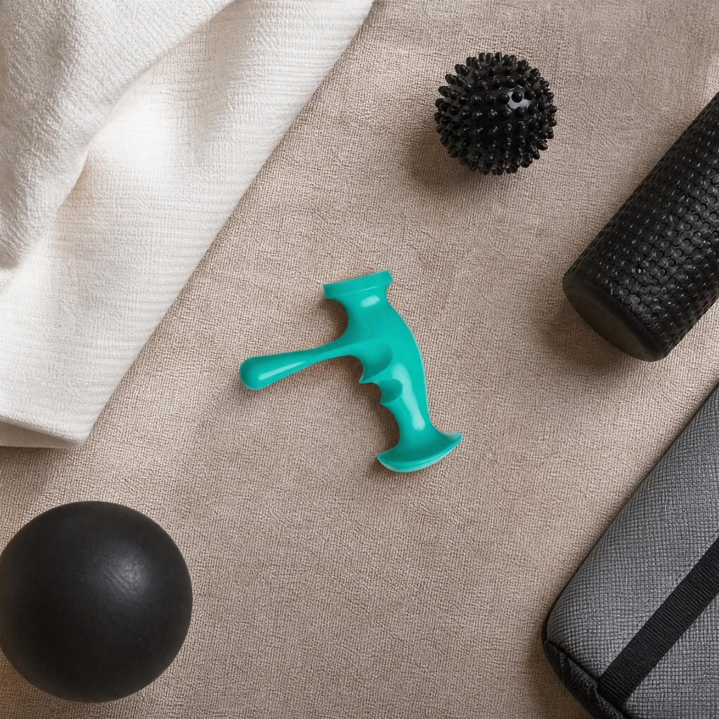 Top-down view of the trigger point massager on a fabric surface, surrounded by massage accessories in a home or therapy setting.