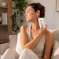 Woman relaxing in a modern living space using a white gua sha massager for self-care.